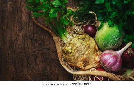 Autumn Food Background With Vegetables, Root Crops In String Bag: Celery, Radish, Parsnips, Carrots. Harvesting, Local Farm Market Shopping, Healthy Eating Concept. Rustic Wood Table. Top View