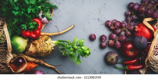 Autumn Food Background With Vegetables, Root Crops And Purple Fruits In String Bag: Celery, Carrots, Apples, Pomegranate, Figs, Grapes. Harvesting, Local Farm Market Shopping, Healthy Eating Concept. 