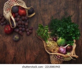 Autumn Food Background With Vegetables, Root Crops And Fruits In String Bag: Celery, Carrots, Apples, Pomegranate, Figs, Grapes. Harvesting, Local Farm Market Shopping, Healthy Eating Concept. 