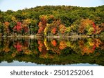 Autumn forest lake. Autumn lake in autumn forest. The autumn foliage of the trees is reflected in the lake water