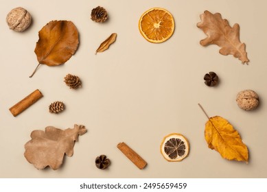 Autumn frame from leaves, nut, cones, dried fruits, cinnamon sticks on beige background. Top view, copy space - Powered by Shutterstock