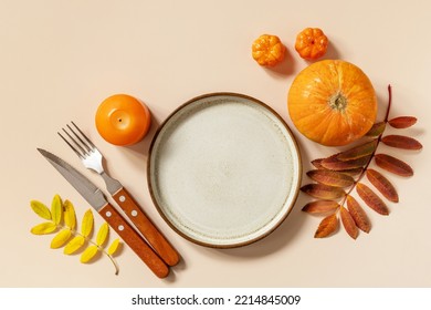 Autumn Halloween Or Thanksgiving Day Table Setting. Autumn Background With An Empty Plate, Cutlery, Pumpkins. Thanksgiving Background Mock Up. View From Above. 