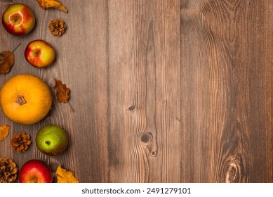 Autumn harvest. Pumpkin, pears, apples, pine cones, and leaves on wooden background. Copy space, top view - Powered by Shutterstock