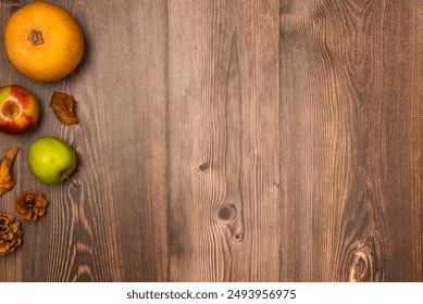 Autumn harvest. Pumpkin, pears, apples, pine cones, and leaves on wooden background. Copy space, top view - Powered by Shutterstock