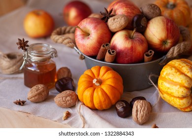 Autumn, harvest season. Apples, pumpkins, walnuts and chestnuts. Served in a metal bowl