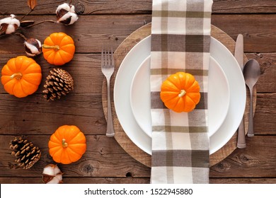 Autumn Harvest Or Thanksgiving Dinner Table Setting With Plate, Silverware, Check Print Napkin, Pumpkins And Decor. Top View On A Rustic Wood Background.