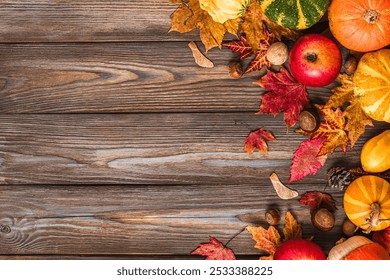 Autumn harvesting and Thanksgiving background. Pumpkins, apples, fall dried leaves, nuts, chestnuts on rustic wooden background. Flat lay. Autumn holidays composition. Top view with copy space - Powered by Shutterstock