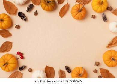 Autumn holiday frame from decorative pumpkins, dried foliage, berry, pinecones and acorns top view. Thanksgiving day, harvest, autumn and fall background top view.