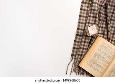 Autumn home cozy composition. Book and scarf, on white background. Flat lay.
