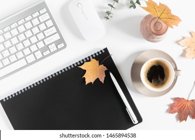 Autumn home cozy composition. Women's home office desk. Dried autumn leaves, cup of coffee, computer, notebook, flowers on white background. Fall background. Flat lay, top view, copy space - Powered by Shutterstock