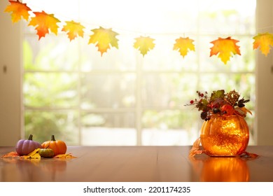 Autumn Home Decoration. Pumpkin Lantern For Thanksgiving Table Setting. Orange Leaves And Flowers Arrangement In Living Room. Fall Colors In House Decor.  Decorated Wooden Table At Big Window.