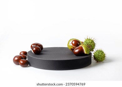 Autumn horse chestnut with peel on a white background. Black podium for your product - Powered by Shutterstock