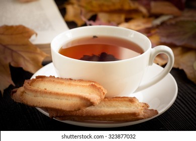 Autumn Hot Tea With Cookies And Falling Leaves Around.