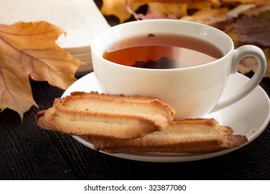 Autumn Hot Tea With Cookies And Falling Leaves Around.