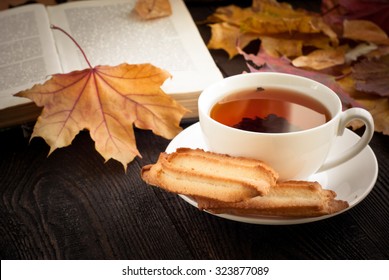 Autumn Hot Tea With Cookies And Falling Leaves Around.