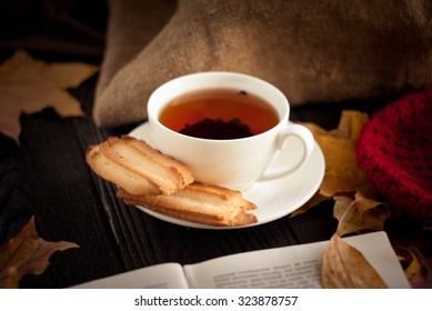 Autumn Hot Tea With Cookies And Falling Leaves Around.