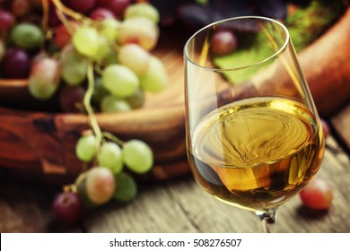 Autumn ice wine, ripe grapes and dried leaves, vintage wooden background, selective focus