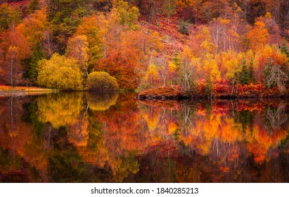 Autumn in Lake District.Colourful trees reflecting in calm water surface.Bright and vibrant landscape scene.Nature background.Autumn walk. - Shutterstock ID 1840285213