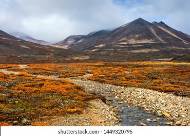 Autumn landscape. Beautiful arctic nature. A small river among the autumn tundra in a mountain valley. Travel to the extreme north. Mountain hikes and adventures. Chukotka, Siberia, Far East of Russia - Shutterstock ID 1449320795