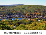 Autumn landscape in Connecticut River Valley. Red and yellow leaves of maples trees sprinkle the hills of New Hampshire and the Green Mountains of Vermont. Forest still mostly green or changing colors