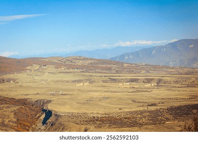 Autumn landscape near Tsodoreti and Tbilisi, featuring open fields, rolling hills, and distant mountains under a clear blue sky. A peaceful midday scene showcasing the calm beauty of nature - Powered by Shutterstock