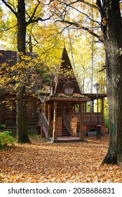 Autumn landscape. An old wooden hut among fallen leaves and autumn trees. Wooden building. Architecture. Yellow trees near the hut.