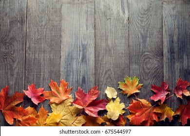 autumn leaf on wood black background (top view) orange leaf on old grunge wood deck, copy place for inscription, top view, tablet for text,