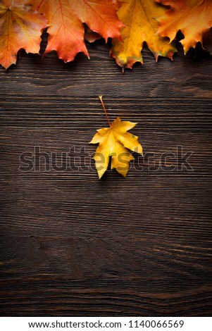 autumn leaf on wood black background (top view) orange leaf on old grunge wood deck, copy place for inscription, tablet for text,
