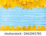 Autumn leaves frame on one down and up side wooden blue background top view Fall Border yellow and Orange Leaves vintage wood table Copy space. Mock up for your design. Display for product or text