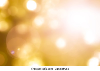 Autumn Leaves In Warm Yellow Gold  Color Blurred Golden Hour Sky Background With Nature Glowing Sun Light Flare, Sunlight Ray And Bokeh