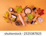 Autumn makeup cosmetics set with cozy beige background with autumn leaves, fall cosmetics sales, autumn seasonal style outlook and makeup 