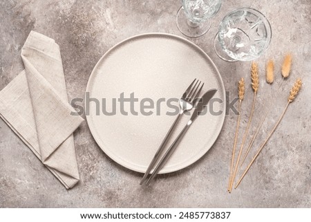 Autumn minimal table setting in beige colors with ears of wheat and lagurus. Top view, flat lay, selective focus.
