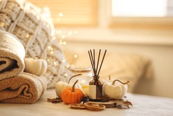 Autumn Mood, Cozy Fall Home Atmosphere. Aroma Diffuser, Pumpkins, Knitted Warm Sweaters, Burning Candles, Dry Leaves On Wooden Table. Concept Of House Decor, Apartment Seasonal Fragrance. Thanksgiving