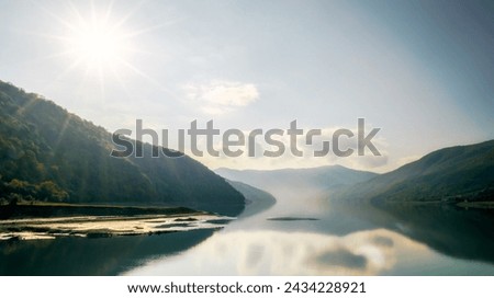 autumn mountain landscape with green forest and lake against the background of the rays of the sun and sky and clouds in Georgia