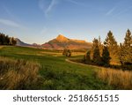 Autumn mountain landscape with meadow, forest and sunlit rocky hills. Beautiful rural landscape of the High Tatras, Krivan. Discover the beauty of autumn.