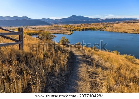 Autumn Mountain Trail - An Autumn day view of a winding biking and hiking trail, overlooking Bear Creek Lake Park, at side of Mt. Carbon. Denver-Lakewood, Colorado, USA.
