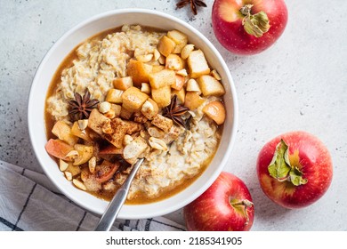 Autumn Oatmeal With Caramelized Apple And Cinnamon In White Bowl, Top View. Winter Cozy Recipe. Healthy Comfort Food.