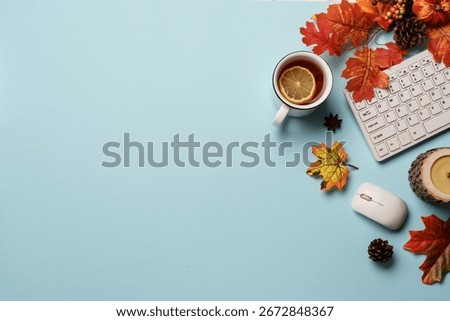 Autumn office table, workspace flat lay background. Laptop, notebook, mug of tea and fallen leaves.