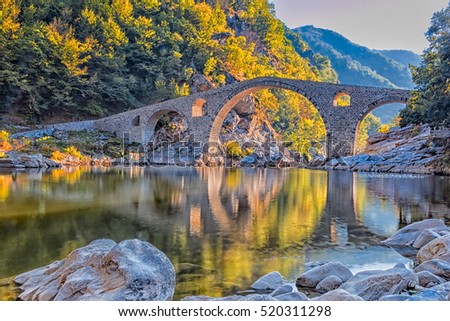 In autumn old stone bridge near Ardino, Bulgaria