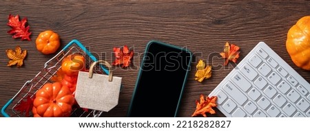 Autumn onlineshopping design concept with shopping cart on wooden table background.