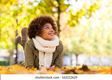 Autumn outdoor portrait of beautiful African American young woman lying down - Black people - Powered by Shutterstock