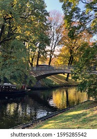 Autumn park with bridge over small river and boat - Shutterstock ID 1595285542