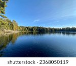 Autumn photos of Northern Ontario Lakes and Trees. Various colours of trees are set against a blue backdrop of the sky. Textures are exaggerated by the rocky shorelines and outcrops.