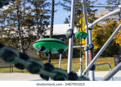 Autumn playground scene - green climbing equipment close-up - vibrant yellow leaves - clear blue sky - sunny day - Powered by Shutterstock