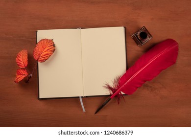 Autumn Poetry. An Open Notebook With A Thorny Branch With Vibrant Leaves, An Ink Well, A Red Quill, Shot From Above On A Dark Rustic Wooden Desk With Copy Space