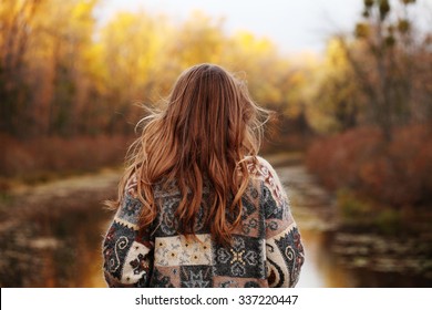 Autumn portrait of girl outdoors with curly hair. Back view. Image toned style instagram filters