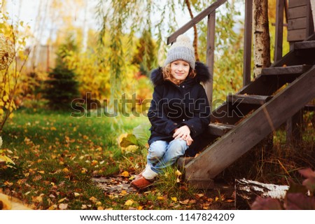 Foto Bild Herbstportrait eines glücklichen Kindes Mädchens im Garten sitzend