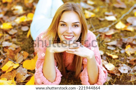 Autumn portrait pretty girl lying on leaves