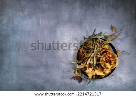 Autumn print with dry leaves of various plants on grayish blue background