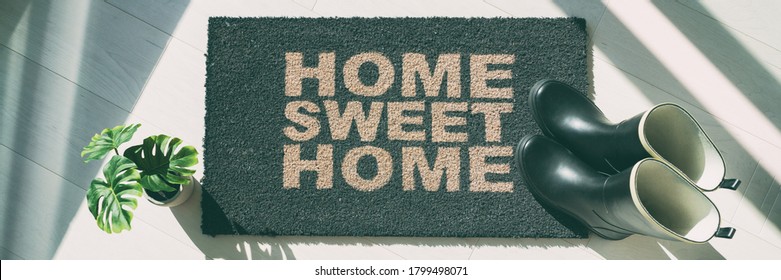 Autumn Rain Boots At Home Door Entrance Home Sweet Home Mat Banner. Panoramic Background Of Shoes Left At House Doormat.